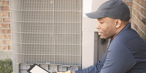 Blue collar air conditioner repairman at work.